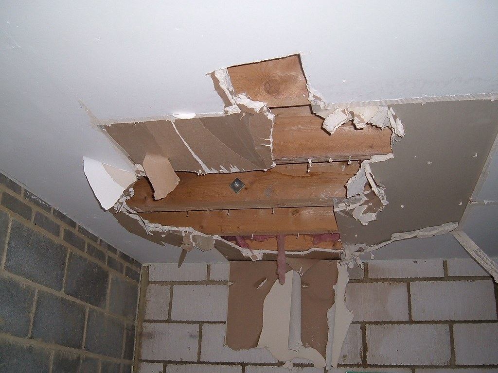 Drywall ceiling torn open and sagging after a water leak from above